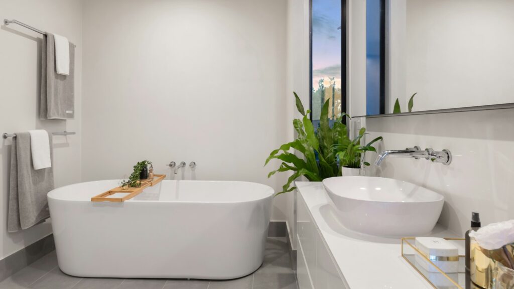 Baño blanco renovado con planta decorativa