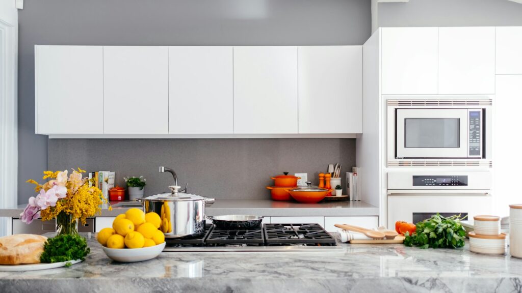 Cocina reformada en blanco con isla de mármol